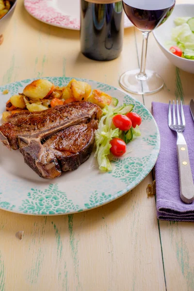 Bife de vitela T-Bone com salada e batatas — Fotografia de Stock