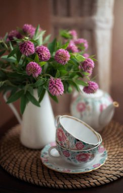 Durgun yaşam. Bir buket yonca ve bir fincan çay..