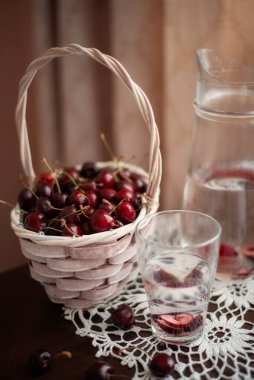 Durgun yaşam. Bir sepet kırmızı kiraz ve bir sürahi su..