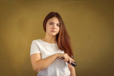 14-15 yaşlarında uzun siyah saçlarını tarayan bir kız. Seçici Odaklanma