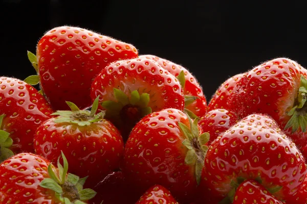 Haufen Erdbeeren auf schwarz — Stockfoto