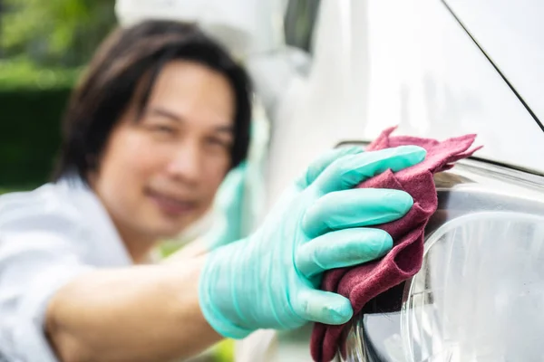 Car cleaning. Hand man in gloves cleaning the headlights of the car and wipes to shine.