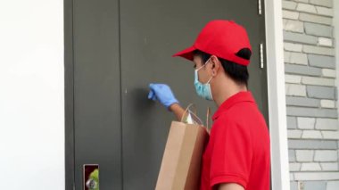 Corona Virüs Konsepti. Koruyucu maske ve tıbbi lastik eldiven takan postacıdan bir paket alıp imzalayan mutlu genç Asyalı kadın. Kurye kavramı, online alışveriş