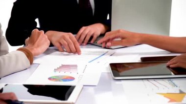 Asyalı işadamları ve iş kadınları evrak işlerini analiz ederler brifing masasında bir araya gelirler takım çalışmasında fikirleri paylaşırlar proje planını tartışırlar küçük modern gece ofisinde başarı stratejisini tartışırlar.