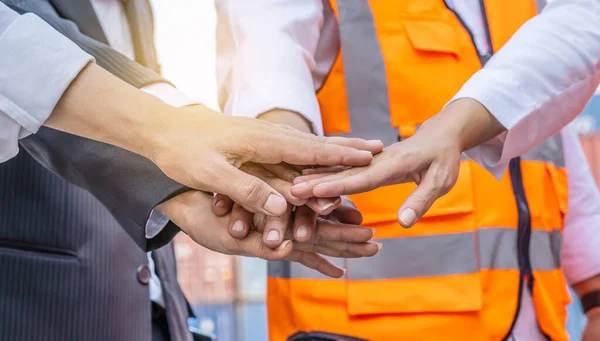 Group of employees and management team wearing logistic uniforms for exporting products abroad, stand to put your hands up and raise your hands together for a harmonious work experience