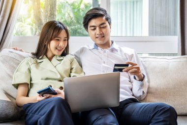 Birkaç arkadaş evdeki bir kanepede oturuyorlar. İnternetten alışveriş yapmak için bilgisayar tuvaleti ve kredi kartı kullanıyorlar. Çift alışverişi ya da internet üzerinden sohbet ediyorlar.