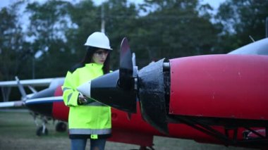 Teknisyen uçağın motorunu tamir ediyor, kadın uzay mühendisi uçak motorlarını kontrol ediyor.