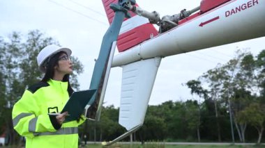 Teknisyen uçağın motorunu tamir ediyor, kadın uzay mühendisi uçak motorlarını kontrol ediyor.