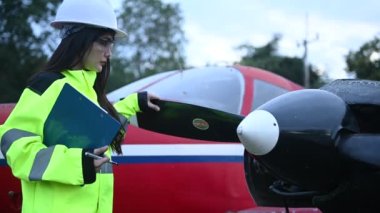 Teknisyen uçağın motorunu tamir ediyor, kadın uzay mühendisi uçak motorlarını kontrol ediyor.