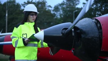 Teknisyen uçağın motorunu tamir ediyor, kadın uzay mühendisi uçak motorlarını kontrol ediyor.