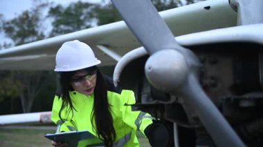 Teknisyen uçağın motorunu tamir ediyor, kadın uzay mühendisi uçak motorlarını kontrol ediyor.