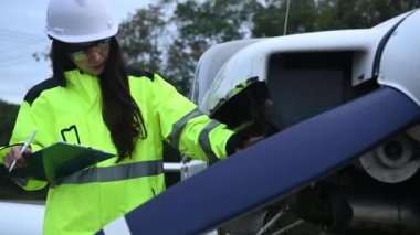 Teknisyen uçağın motorunu tamir ediyor, kadın uzay mühendisi uçak motorlarını kontrol ediyor.