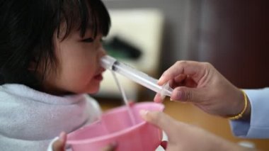 Küçük kız ve burun yıkama sümüğü burundan atmak için.