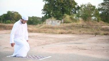 Genç Asyalı Müslüman adam gündüz dua ediyor, Ramazan festivali konsepti.