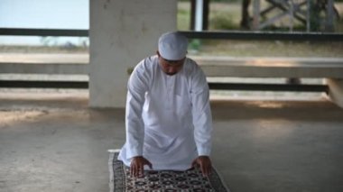 Genç Asyalı Müslüman adam gündüz dua ediyor, Ramazan festivali konsepti.