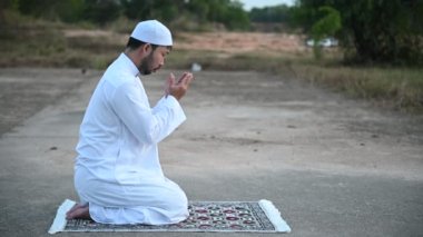 Genç Asyalı Müslüman adam gündüz dua ediyor, Ramazan festivali konsepti.