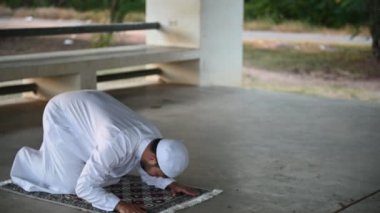 Genç Asyalı Müslüman adam gündüz dua ediyor, Ramazan festivali konsepti.