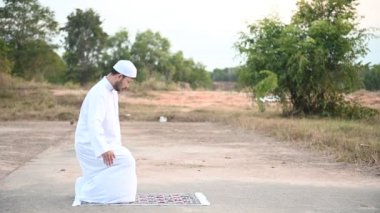 Genç Asyalı Müslüman adam gündüz dua ediyor, Ramazan festivali konsepti.