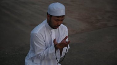Genç Asyalı Müslüman adam gündüz dua ediyor, Ramazan festivali konsepti.