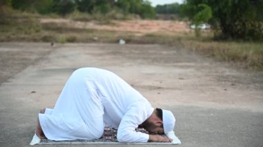 Genç Asyalı Müslüman adam gündüz dua ediyor, Ramazan festivali konsepti.