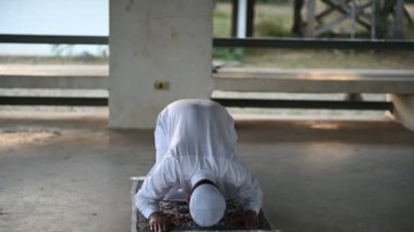 Genç Asyalı Müslüman adam gündüz dua ediyor, Ramazan festivali konsepti.