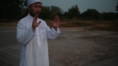 Genç Asyalı Müslüman adam gündüz dua ediyor, Ramazan festivali konsepti.