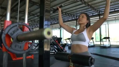 Güzel Asyalı kadın spor salonunda antrenman yapıyor.