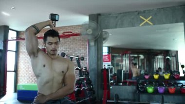 Spor salonunda kaslı Asyalı bir adam, vücut ağırlığı eğitimi. 