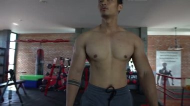 Spor salonunda kaslı Asyalı bir adam, vücut ağırlığı eğitimi. 