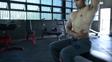 Spor salonunda kaslı Asyalı bir adam, vücut ağırlığı eğitimi. 