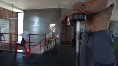 Spor salonunda kaslı Asyalı bir adam, vücut ağırlığı eğitimi. 