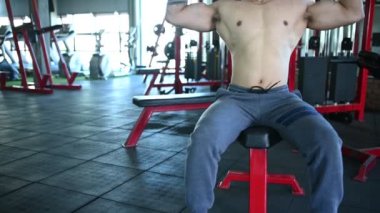 Spor salonunda kaslı Asyalı bir adam, vücut ağırlığı eğitimi. 