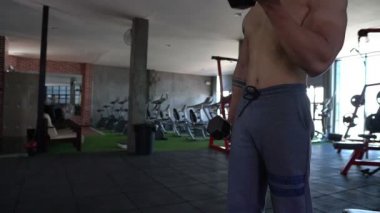 Spor salonunda kaslı Asyalı bir adam, vücut ağırlığı eğitimi. 