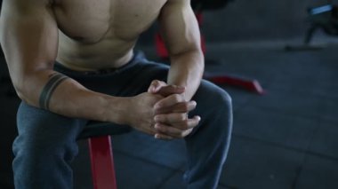 Büyük kaslı Asyalı adam spor salonunda ağırlık çalışması yapıyor.