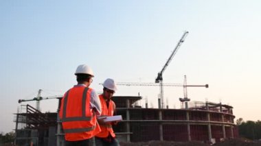 İnşaat tarafında çalışan iki mühendis, sorunları çözümlemede birbirlerine yardım ediyorlar.