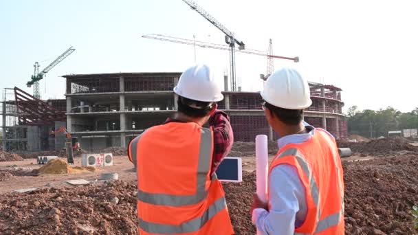 Zwei Ingenieure Die Auf Der Seite Des Gebäudes Arbeiten Und — Stockvideo