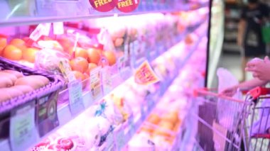 Maskeli Asyalı anne ve kız süpermarkette alışveriş yapıyorlar, covid-19 konsepti.