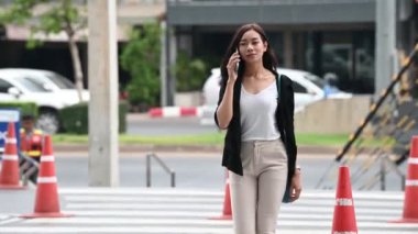 Genç Asyalı güzel iş kadını mağazada yürüyor.
