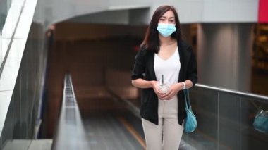 Genç Asyalı güzel iş kadını mağazada yürüyor.