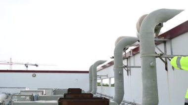 Klima teknisyeni binanın dışındaki birimleri tamir ediyor ve muhafaza ediyor.