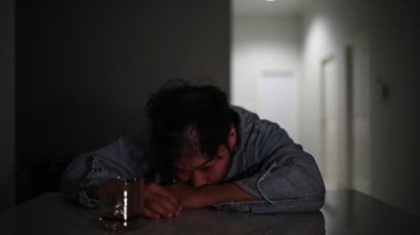 Evde masada otururken sigara içen sarhoş erkek alkolik, alkol bağımlılığı konsepti