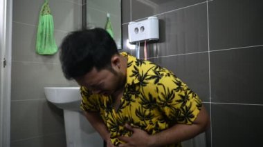 asain adam klozetin üzerinde oturuyor, kabızlık konsepti.