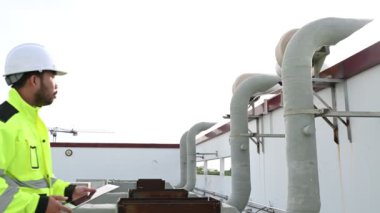 Klima teknisyeni binanın dışındaki birimleri tamir ediyor ve muhafaza ediyor.