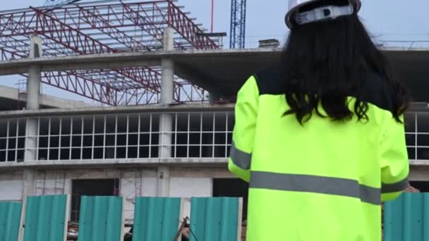 大規模な建築プロジェクトの現場で働くアジアの女性エンジニア — ストック動画