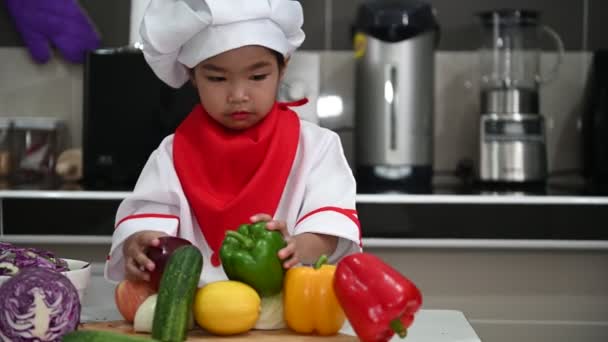 Mignonne Asiatique Fille Portant Chef Uniforme Avec Beaucoup Légumes Sur — Video