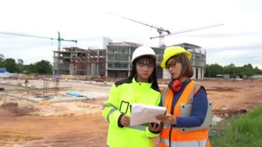 Mühendisler inşaat halindeki büyük binanın çalışmalarını tartışıyorlar