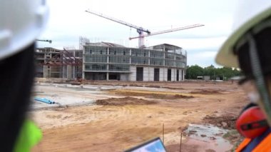 Mühendisler inşaat halindeki büyük binanın çalışmalarını tartışıyorlar