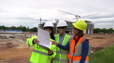 Mühendisler inşaat halindeki büyük binanın çalışmalarını tartışıyorlar
