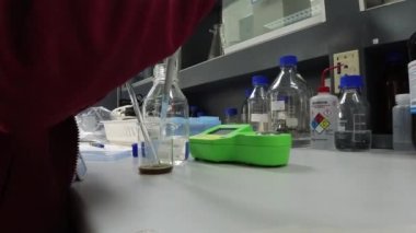 Laboratuvarda antiretroviral ilaçlar bulmak için kimyasalları karıştıran kimyagerleri kapatın. Coronavirus konsepti.