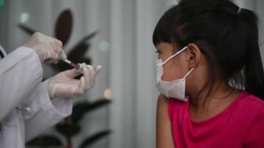 Virüsü koruyan Asyalı doktor enjeksiyon aşısı covid-19 tıbbi maske takıyor